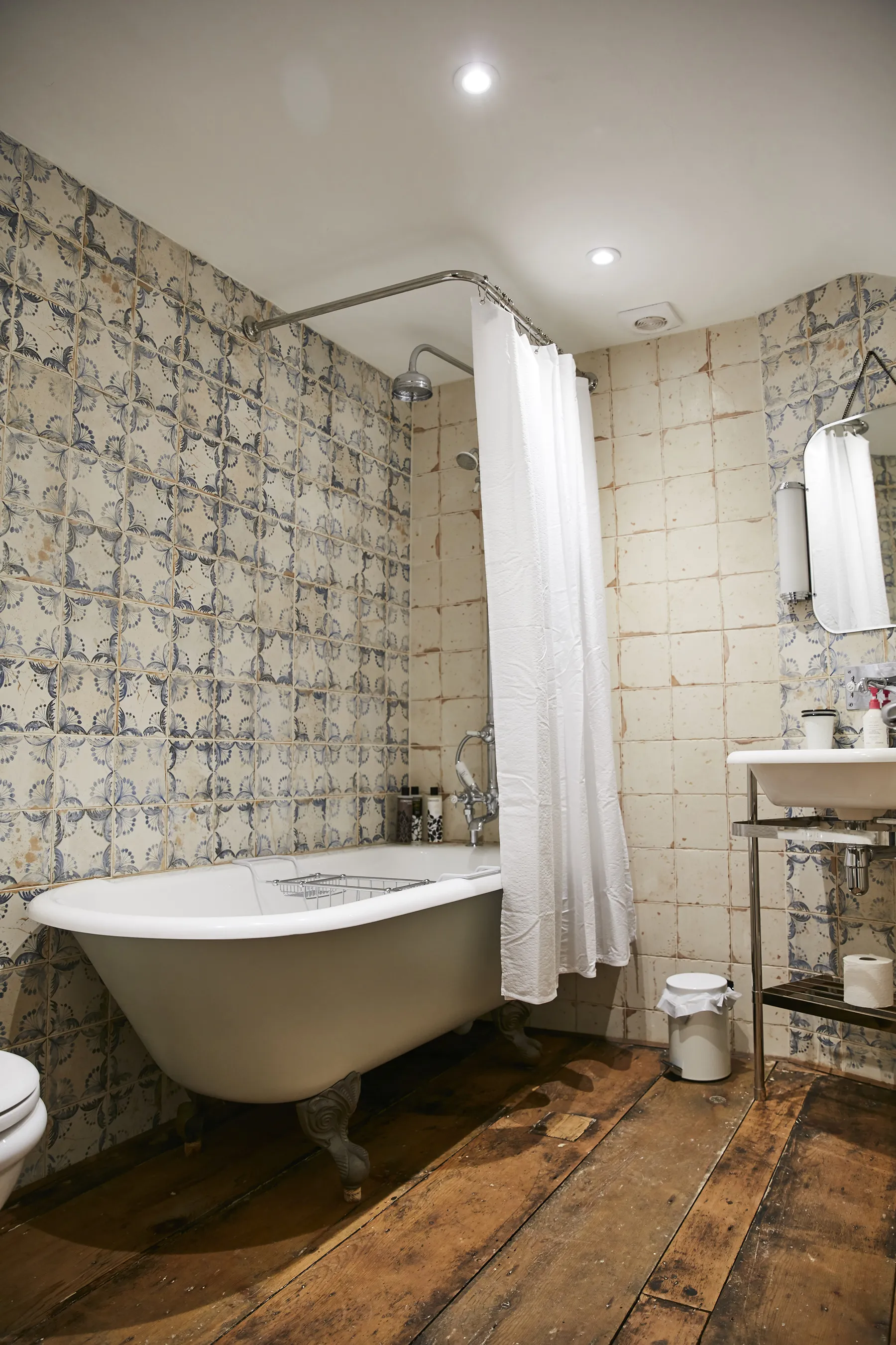 Bathroom with roll top bath and shower over